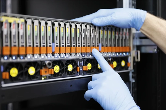 Technicians in a cleanroom working on enterprise data recovery with multiple hard drives and specialized equipment.