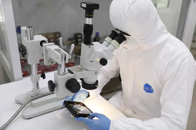 Technician performing a hard drive recovery process in a cleanroom, using advanced tools and equipment.