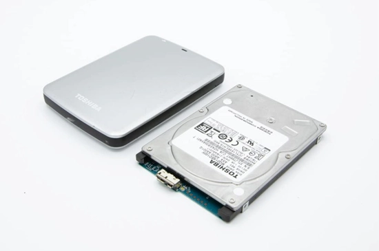 Toshiba external hard drive connected to a computer, with a focus on its sleek design and portability.