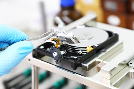 Technician performing data recovery on a WD NAS device, using specialized tools and equipment in a lab setting.